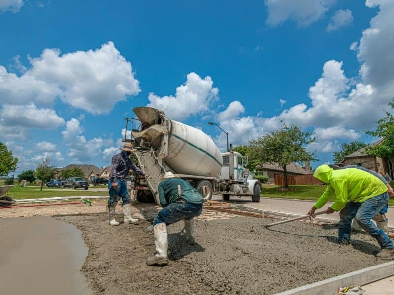 Heavy machinery performing earthwork grading and soil leveling on a construction site with excavators and dump trucks shaping the terrain.
